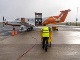 Airport staff loading luggage on plain