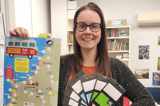 Librarian with reading program poster and prizes